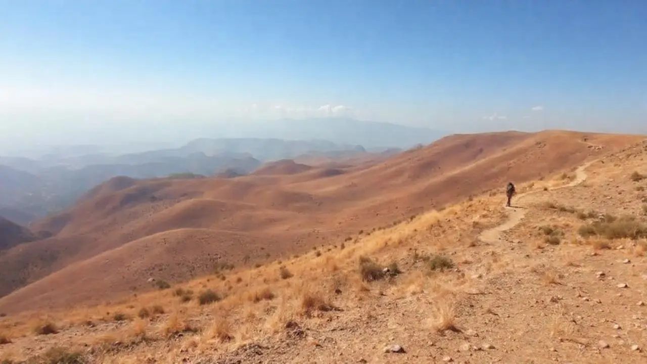 Paisaje árido y vasto, con figura solitaria