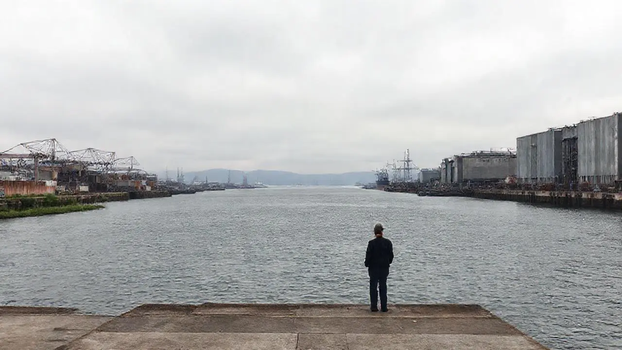 Puerto industrial sereno, ambiente brumoso y distante