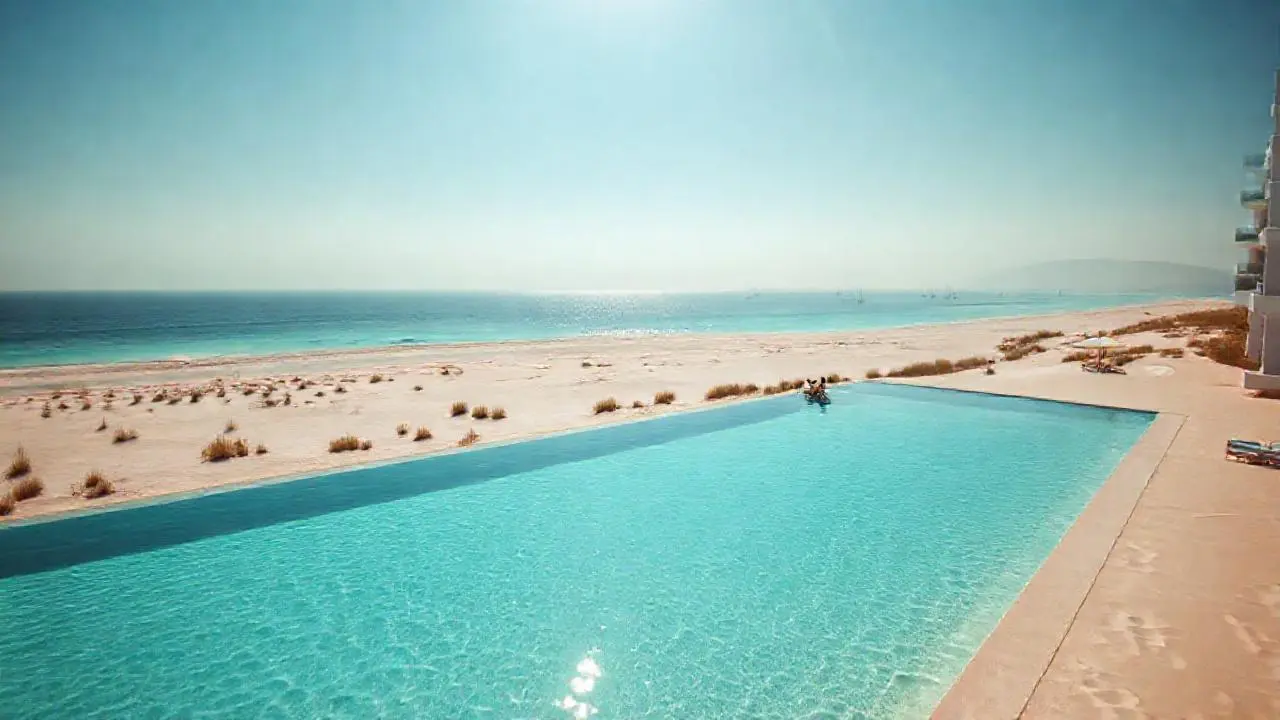 Playa tranquila, resort moderno y luz cálida