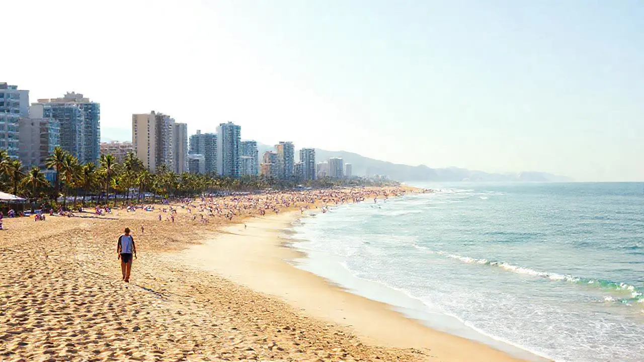 Playa concurrida, moderna y soleada