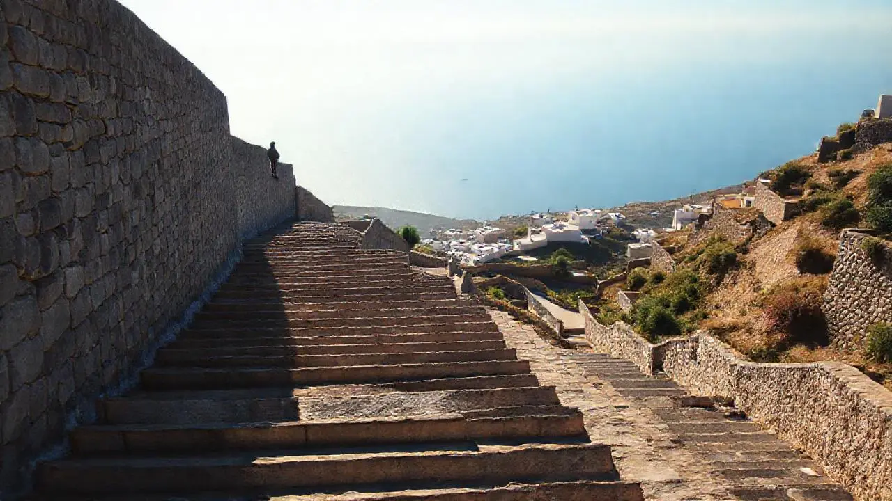 Escalera de piedra, luz cálida y mar lejano