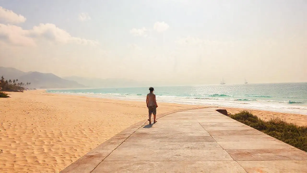 Tranquila playa, figura solitaria bajo el sol