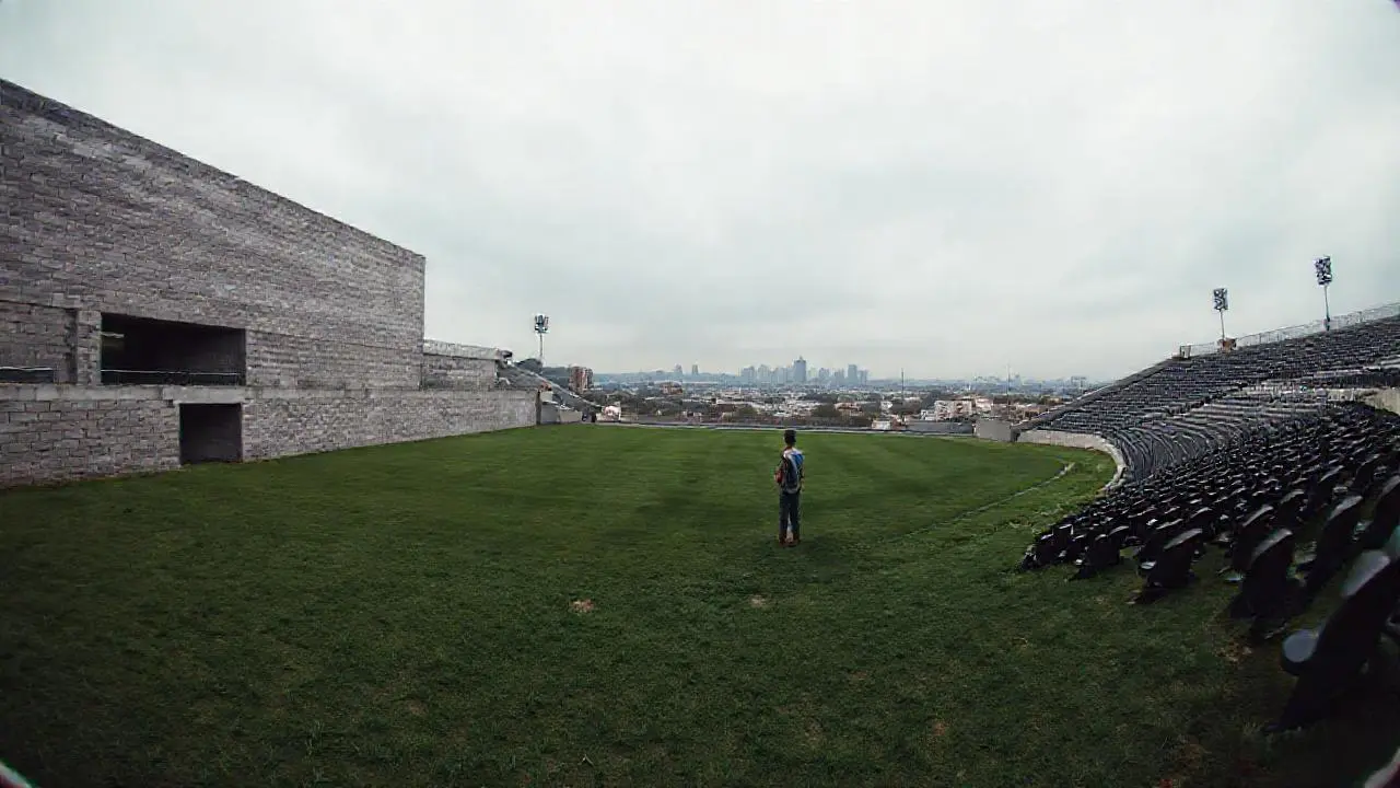Estadio vacío bajo cielo nublado y bruma