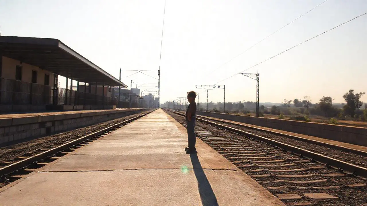 Plataforma silenciosa, figura solitaria bajo la luz