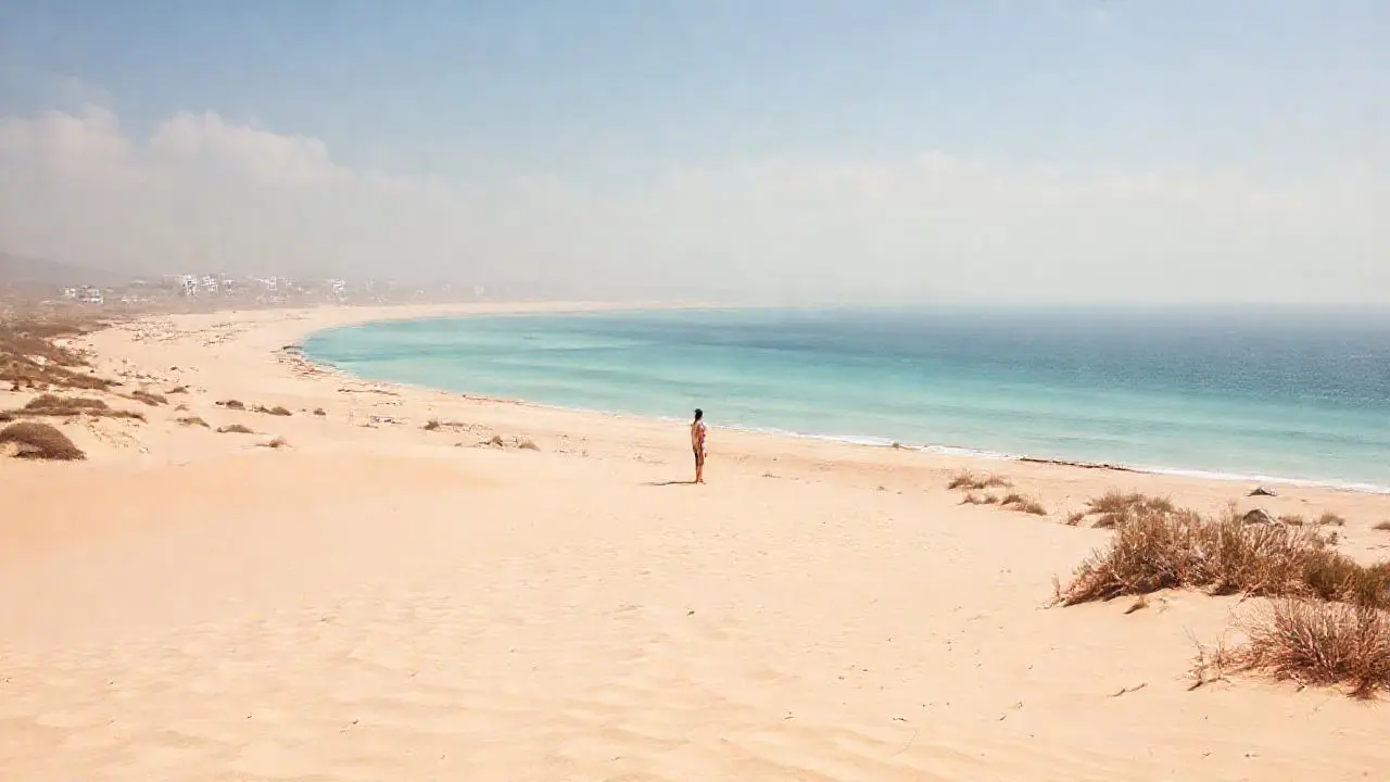 Playa serena, luz cálida, ambiente relajado