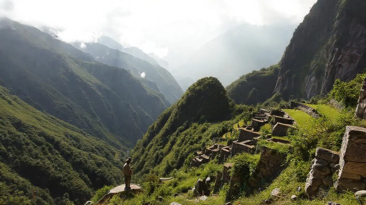 Paisaje montañoso extenso, brumoso y antiguo