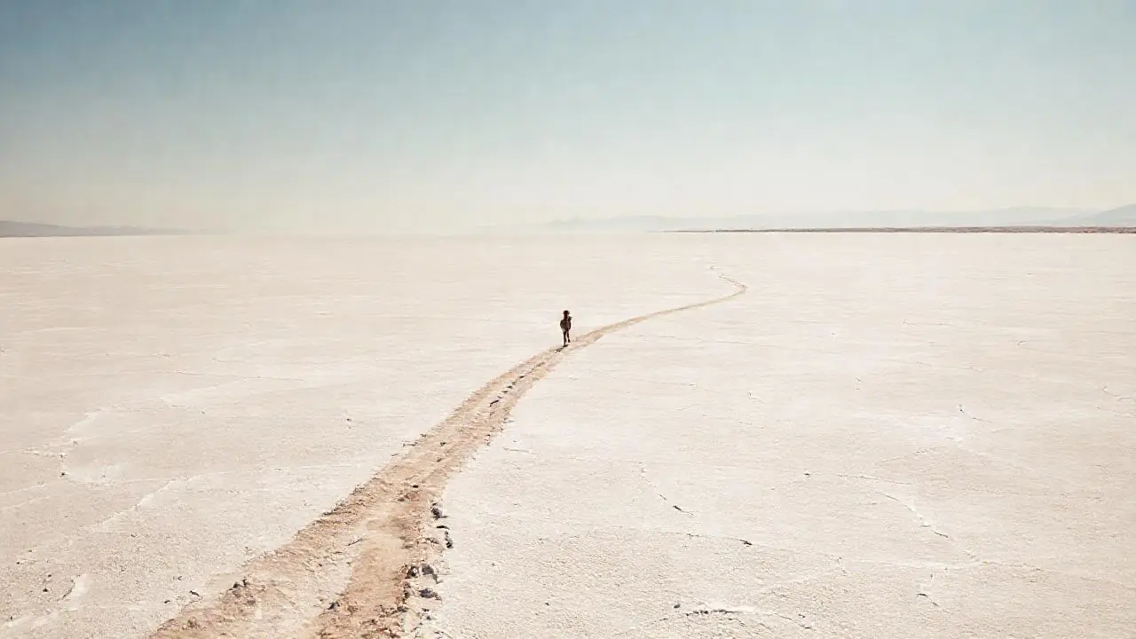 Inmensa salina, figura solitaria, horizonte vasto