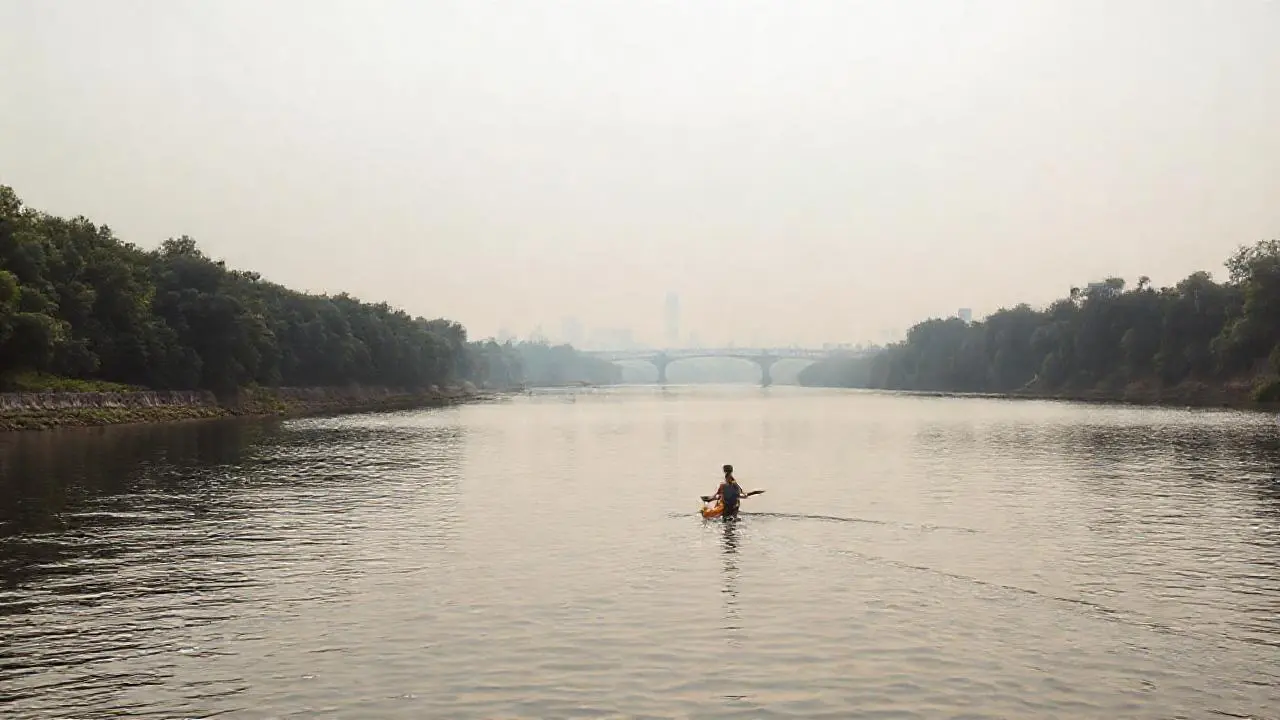 Un kayakista en un río tranquilo y vasto