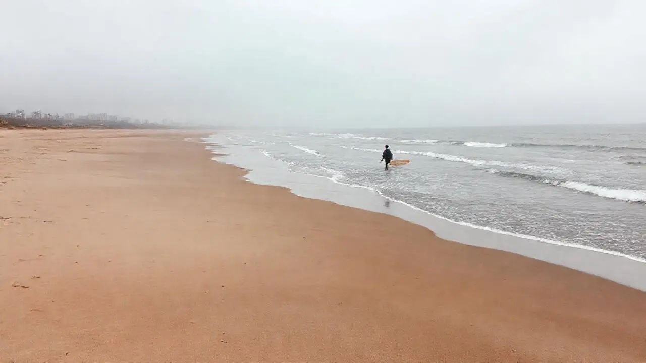 Playa amplia, grisácea y serena