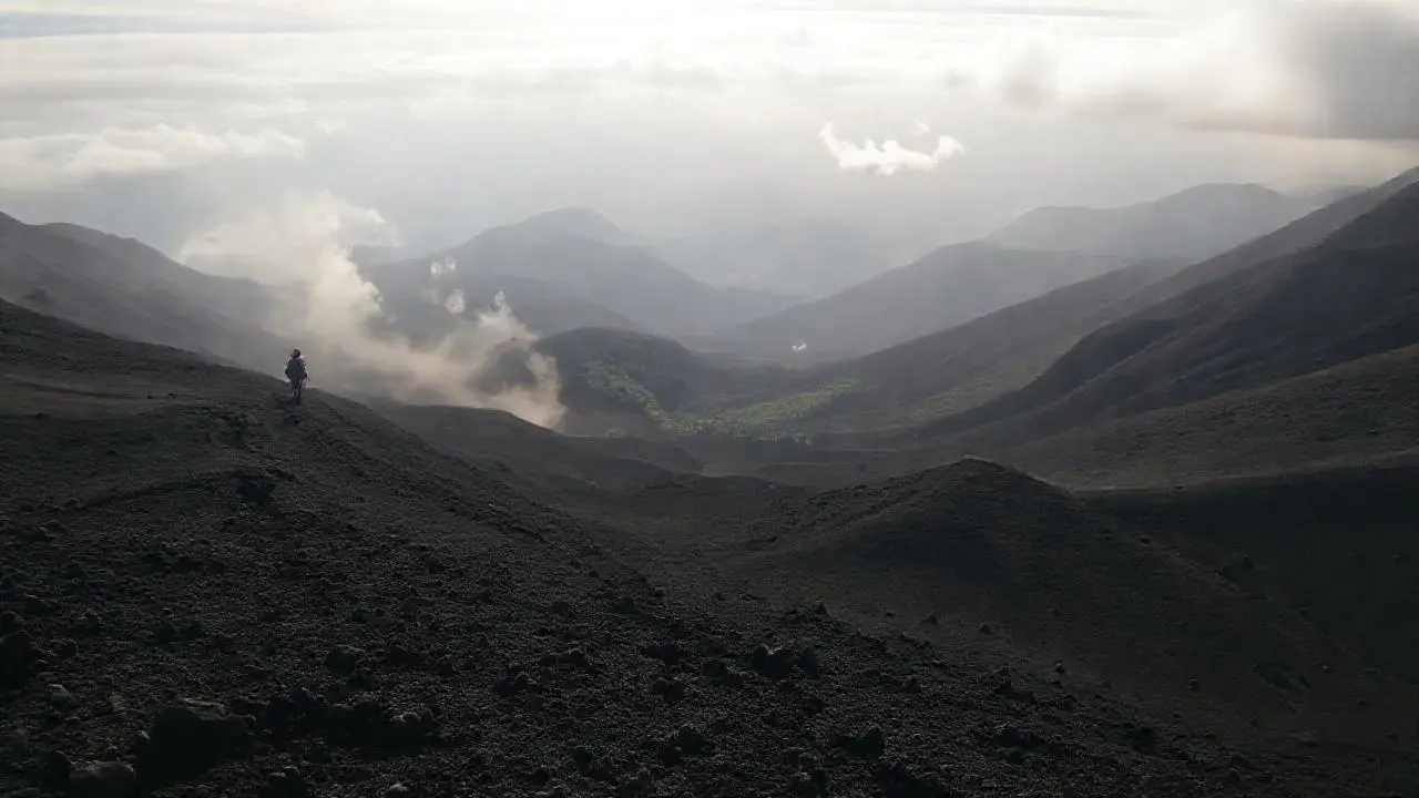 Paisaje volcánico extenso, brumoso y agreste