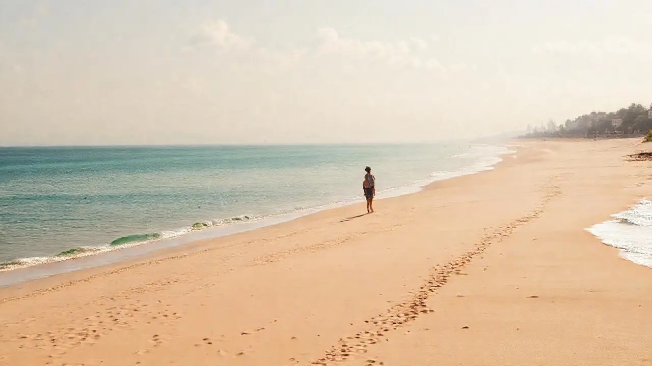 Playa serena, luz cálida, horizonte amplio