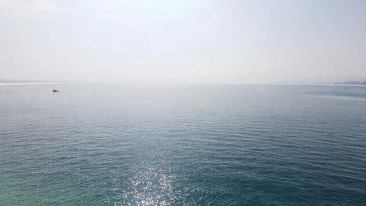Mar sereno, luz cálida, horizonte difuso