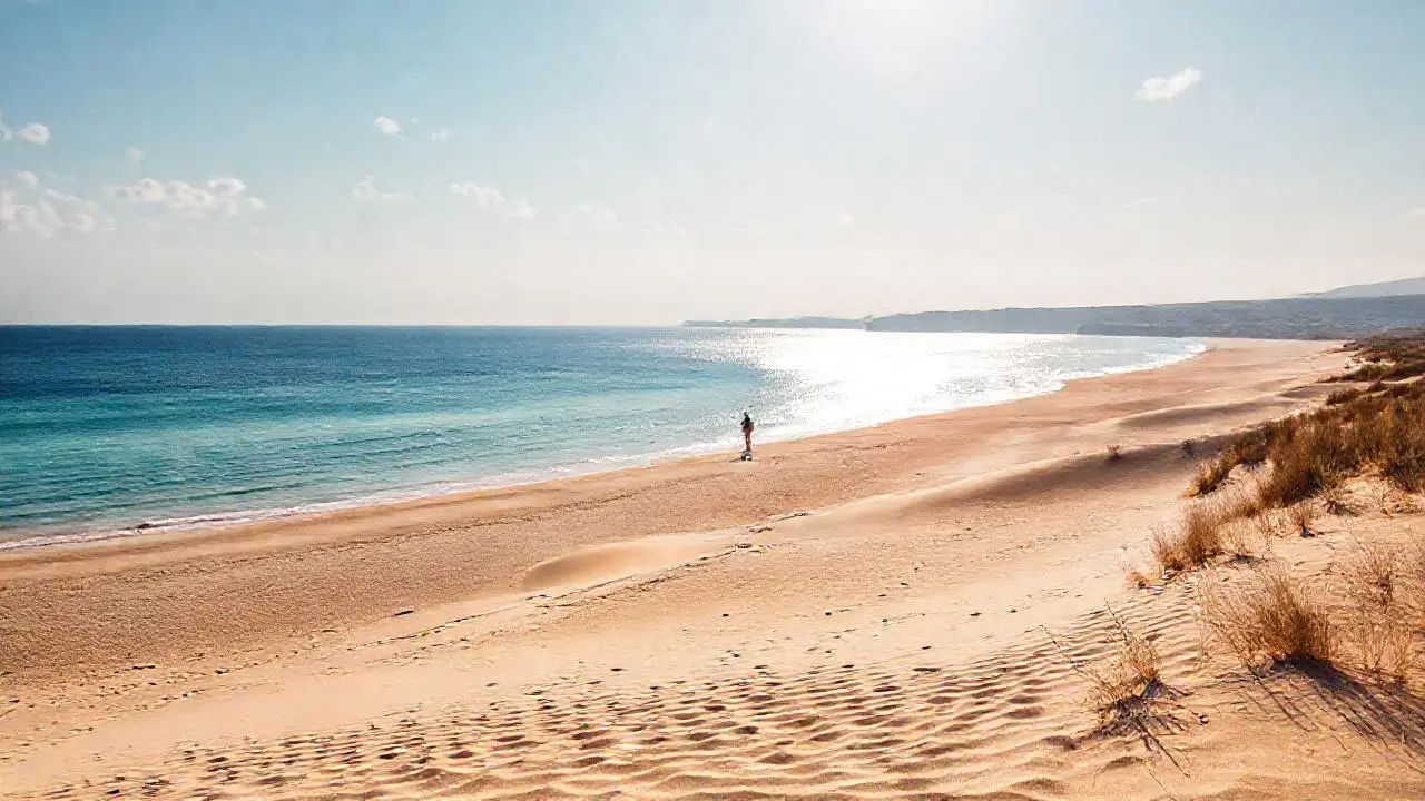 Playa extensa, luz dorada, paz serena