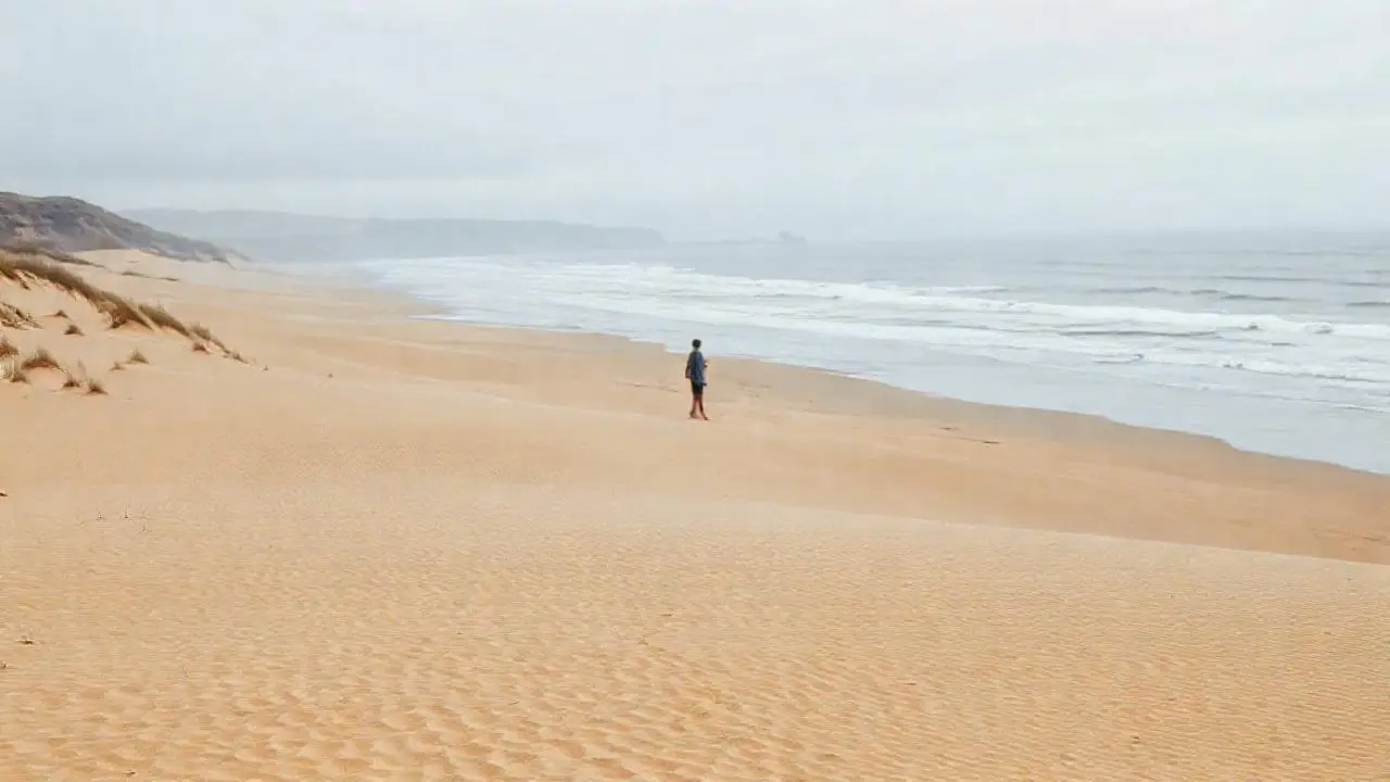 Playa extensa y tranquila bajo cielo nublado