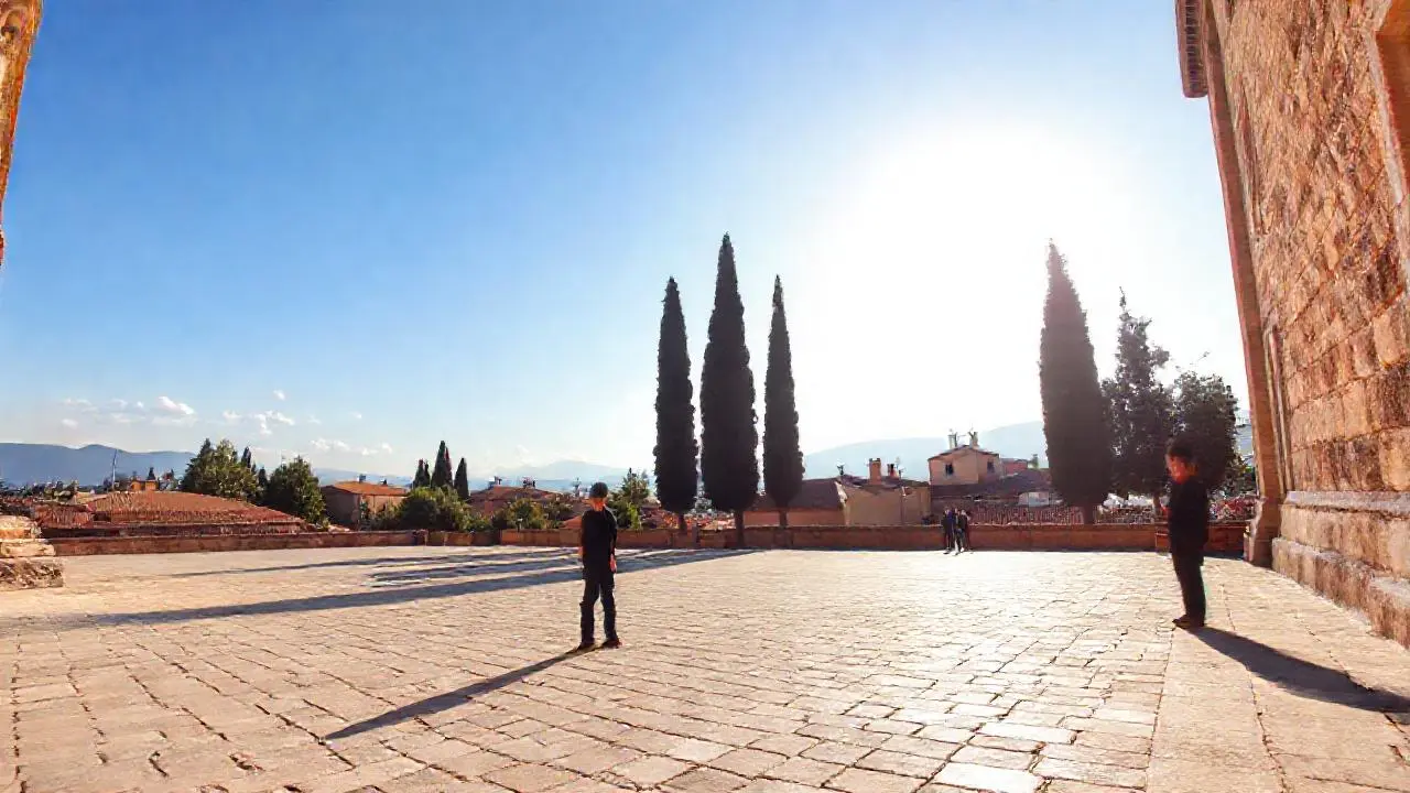 Plaza soleada con arquitectura antigua y ambiente tranquilo