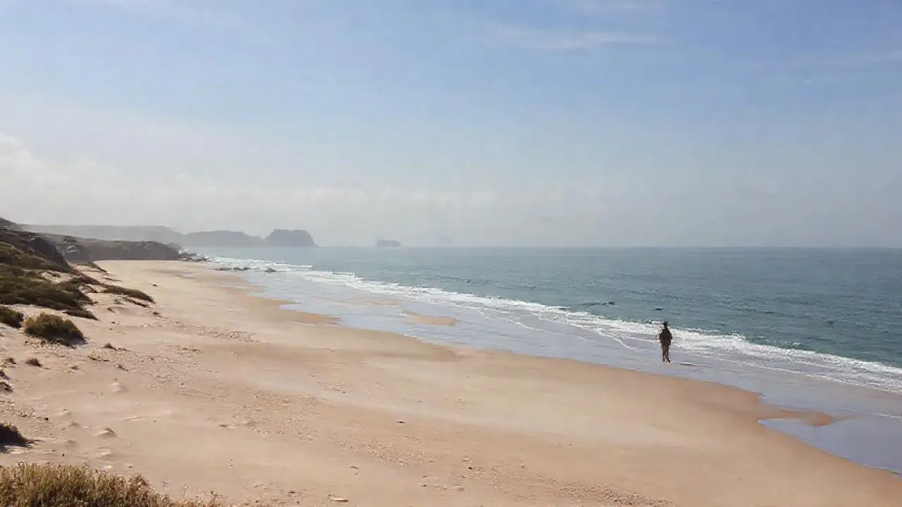 Costa serena, inmensa y ligeramente brumosa