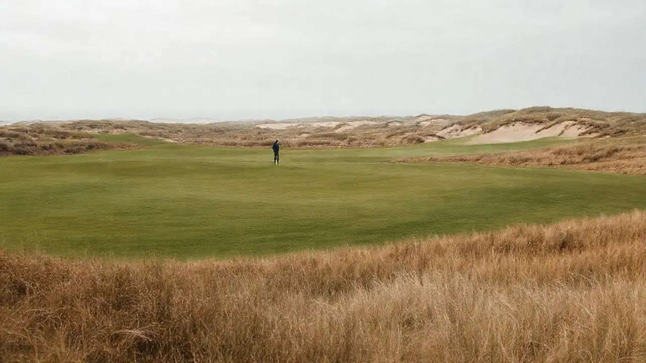 Paisaje costero, golfista solitario, ambiente vasto