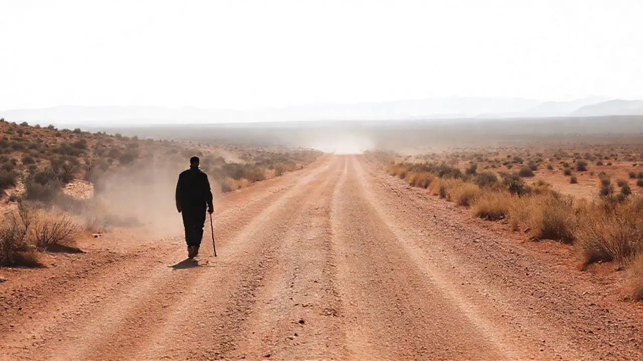 Camino árido, figura solitaria y lejana