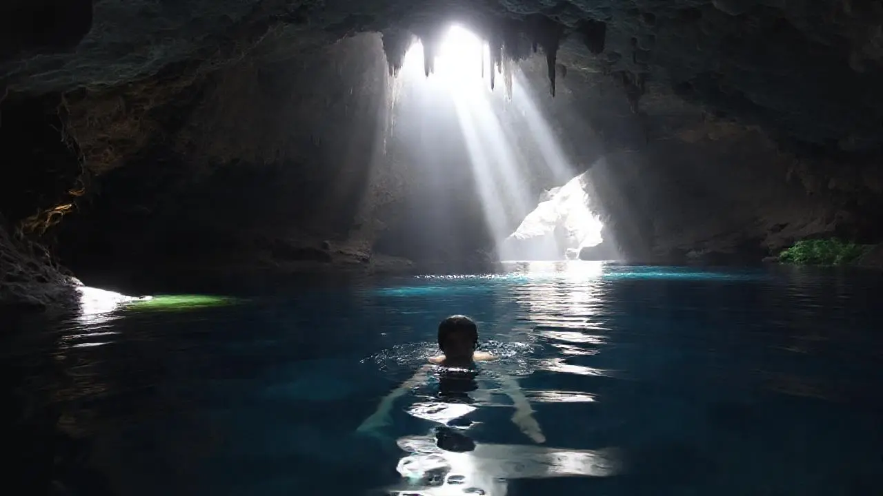 Un nadador descansa en una cueva oscura