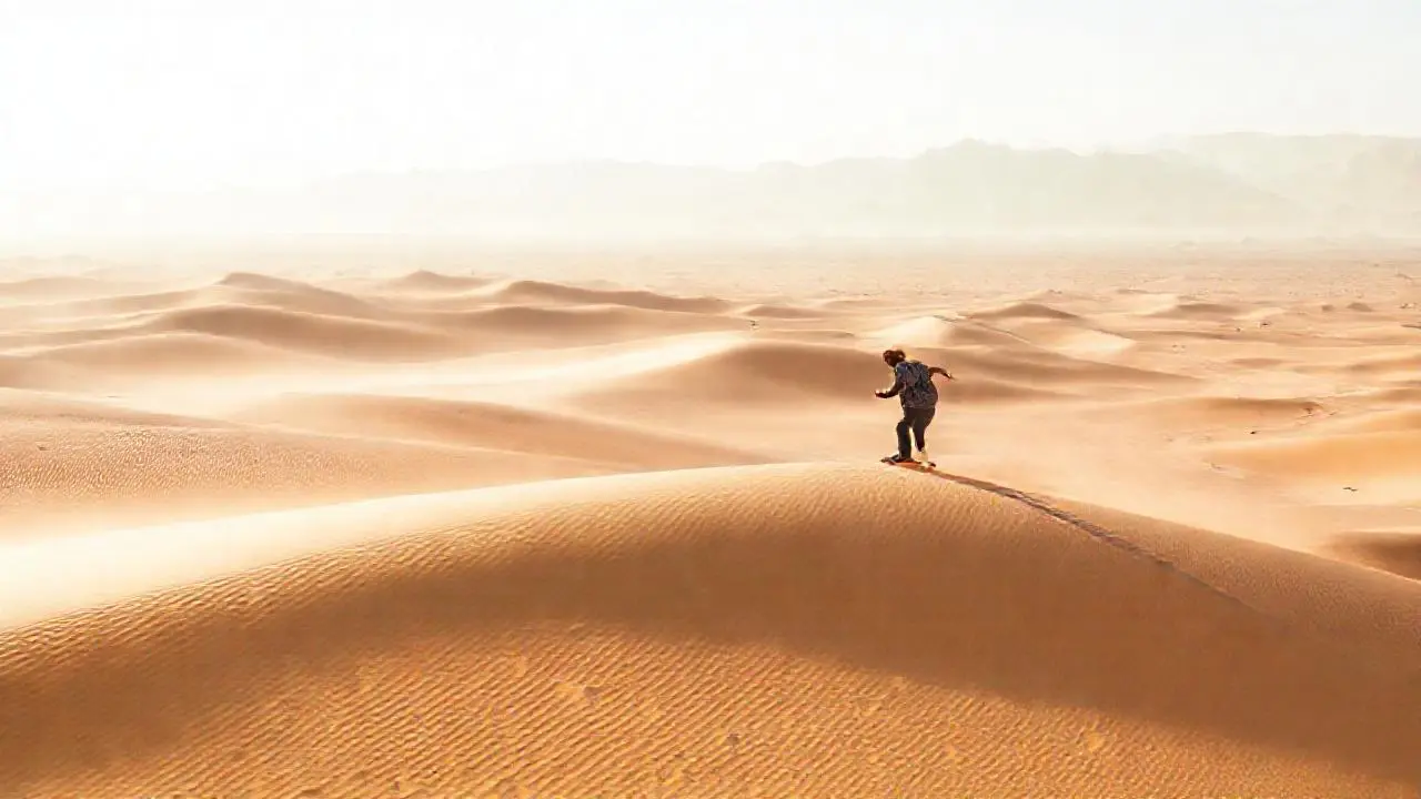 Un desierto infinito con una figura deslizándose