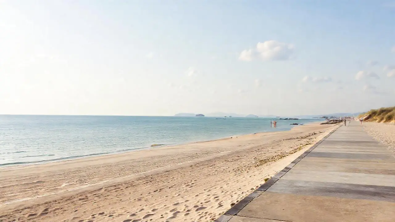 Tranquila playa al atardecer, serena y amplia