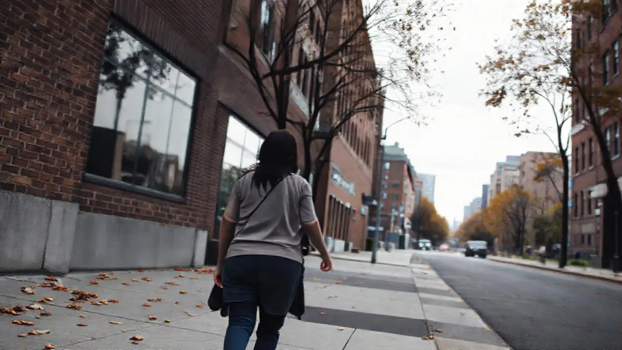 Calle urbana gris, mujer caminando sola