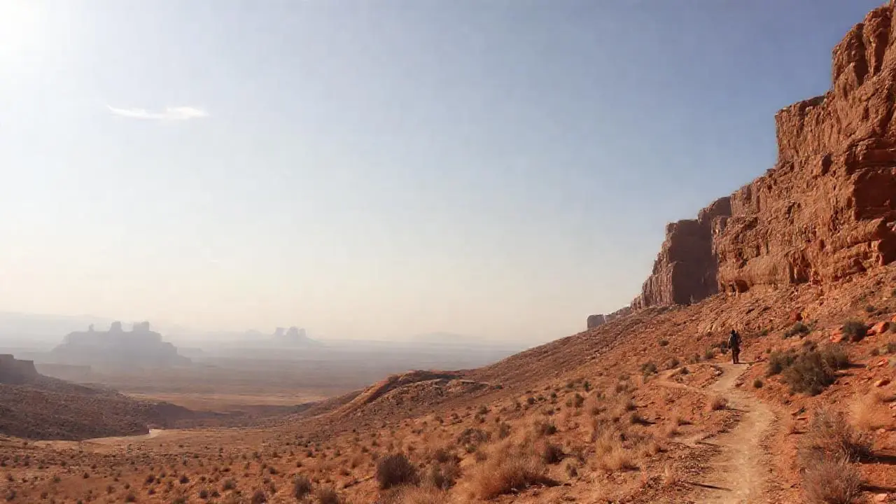 Paisaje árido y vasto, con una figura solitaria