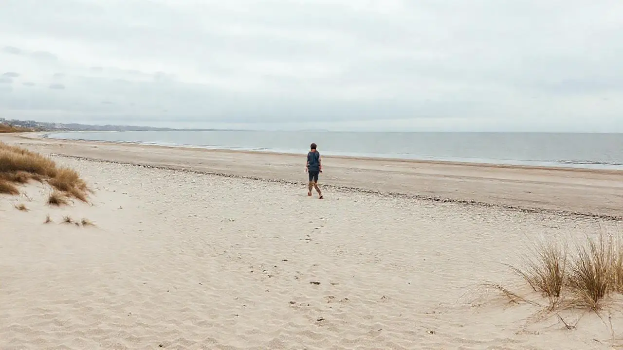 Playa tranquila, figura solitaria en calma