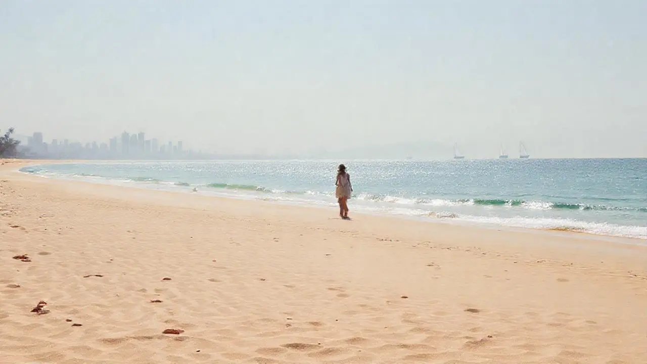Playa serena, luz cálida, figura solitaria