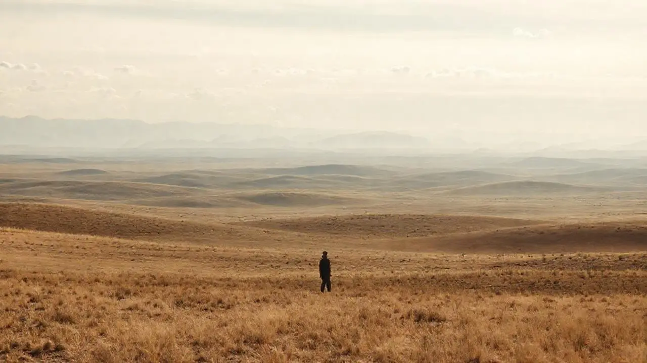 Paisaje vasto y silencioso, figura solitaria